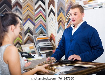 Portrait Of Happy American Man Seller Taking Order On Picture Frame From Customer At Counter In Store 