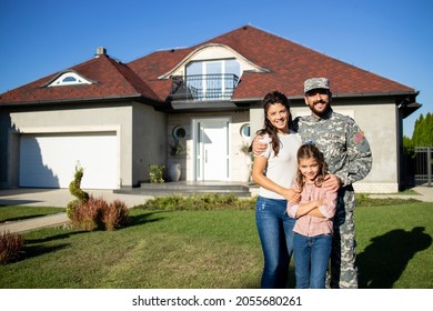 Portrait Of Happy American Military Family In Front Of Their House.