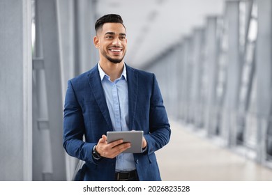 Portrait Of Happy Arab Man With Digital Tablet Standing At Airport Terminal, Handsome Middle Eastern Businessman Using Tab Computer While Waiting For Flight Departure, Enjoying Business Trip - Shutterstock ID 2026823528