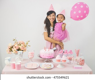 Portrait Of Happy Asian Baby Girl Celebrating Her First Birthday With Mother At Home