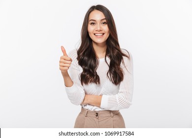 Portrait of a happy asian businesswoman showing thumbs up isolated over white background