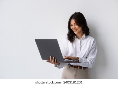 Portrait of a happy asian businesswoman working on laptop computer isolated over white background - Powered by Shutterstock