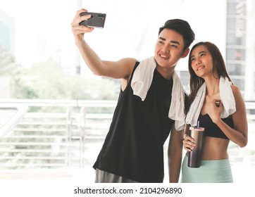 Portrait Of Happy Asian Couple Wearing Sportswear, Running In The Morning At Park And Use Smart Phone Selfie Together.Sport And Health Concept.