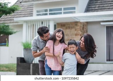 Portrait Of Happy Asian Family In Front Of Their New House