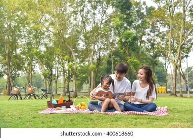 Portrait of happy Asian family, parents and daughter enjoying picnic meal in garden.Asian, Asian family, picnic, love, relationship, outdoors meal, park, family activities or happy garden concept - Powered by Shutterstock