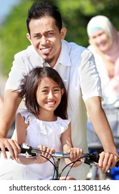 Portrait Of Happy Asian Family Riding Bikes Outdoor