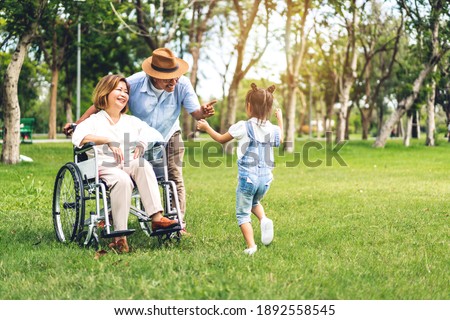 Similar – Woman carrying her mother in a wheelchair