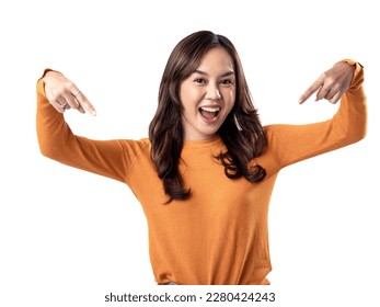 A portrait of a happy Asian Indonesian woman wearing an orange sweater, seen pointing towards a certain direction, isolated on a white background - Shutterstock ID 2280424243
