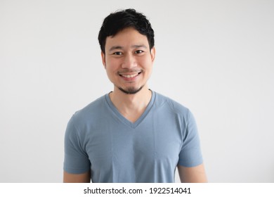 Portrait of happy Asian man in blue t-shirt on isolated white background.