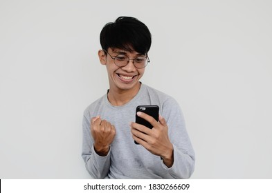 Portrait of a happy asian man looking at a smartphone