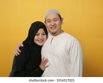 Portrait of happy Asian muslim couple smiling, husband and wife hugging full of love, family concept