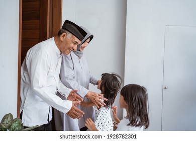 Portrait Of Happy Asian Muslim Family Visiting Grandparents On Ramadan Kareem. Indonesian People Celebrating Eid Mubarak