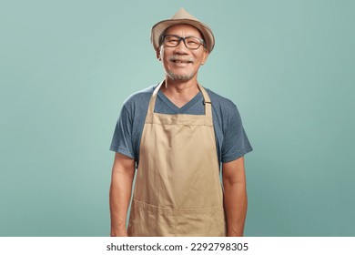 Portrait of Happy Asian Senior man wearing brown apron smiling looking at camera over isolated color background, Small business owner, Entrepreneur - Powered by Shutterstock