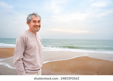 portrait happy asian senior man with grey hair and beard while walking along the beach,concept of senior lifestyle,travel,relaxing in nature                              - Powered by Shutterstock