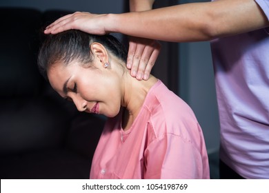 Portrait Of Happy Asian Smile Beautiful Woman Massaging Neck By Professional Massager And Relaxing In Spa. Body Care Treatment By Thai Massage. Cute Girl With Traditional Dress.