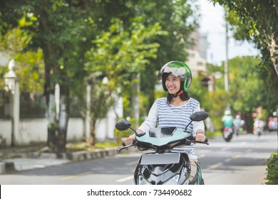 Portrait Of Happy Asian Woman Riding On Motorbike In City Street