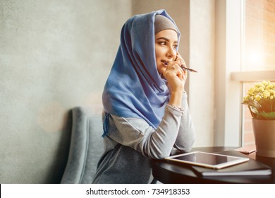 portrait of happy asian woman wearing hijab calling with mobile phone