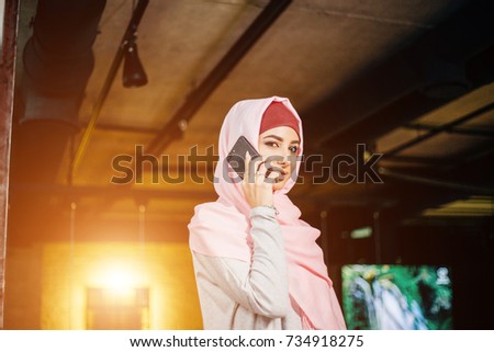 portrait of happy asian woman wearing hijab calling with mobile phone