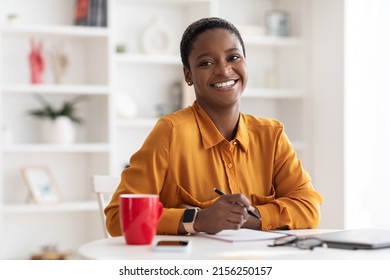 Portrait Of Happy Attractive Short-haired Millennial Black Lady In Casual Outfit Working At White Cozy Office, Taking Notes, Copy Space. Millennials Lifestyles, Job Opportunities For Young People