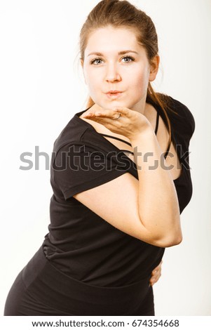 Portrait of happy attractive woman having long brown straight hair wearing black tshirt sending air kisses