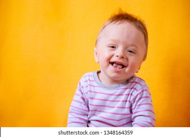 Portrait Of A Happy Baby Boy Under One Year (8 Months) Old, With A Solid Yellow Background