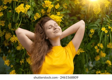 Portrait of happy beautiful bearded girl, young positive woman with beard is smelling beautiful yellow flowers in the garden, smiling, enjoying spring or summer day, breathing deep deeply fresh air - Powered by Shutterstock