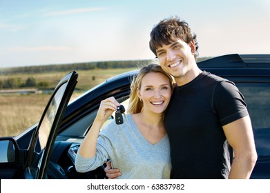 Portrait Of Happy Beautiful Couple Showingh The Keys Standing Near The Car