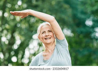 Portrait of a happy beautiful elderly senior mature woman exercising and stretching outdoors - Powered by Shutterstock