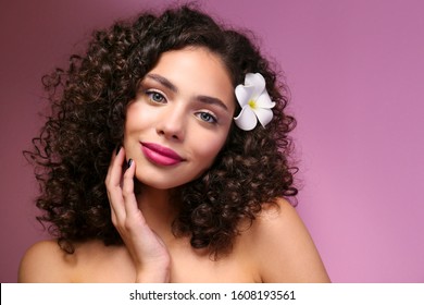 Portrait Of Happy Beautiful Woman With Long Bouncy Curls Hairstyle And Professional Make Up On, Posing Over Isolated Purple Background. Fashion Shot Of Young Gorgeous Female. Close Up, Copy Space.