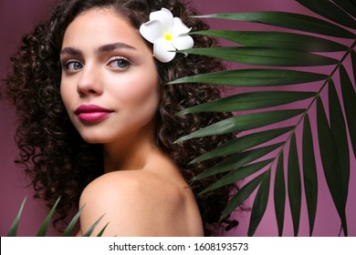 Portrait Of Happy Beautiful Woman With Long Bouncy Curls Hairstyle And Professional Make Up On, Posing Over Isolated Purple Background. Fashion Shot Of Young Gorgeous Female. Close Up, Copy Space.