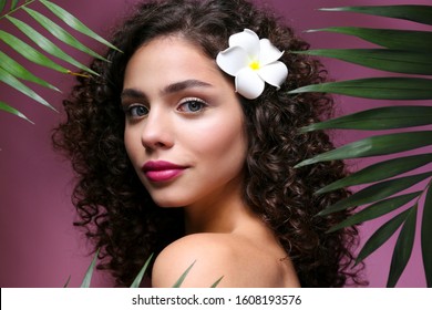 Portrait Of Happy Beautiful Woman With Long Bouncy Curls Hairstyle And Professional Make Up On, Posing Over Isolated Purple Background. Fashion Shot Of Young Gorgeous Female. Close Up, Copy Space.