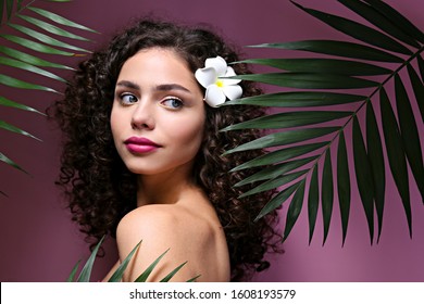 Portrait Of Happy Beautiful Woman With Long Bouncy Curls Hairstyle And Professional Make Up On, Posing Over Isolated Purple Background. Fashion Shot Of Young Gorgeous Female. Close Up, Copy Space.