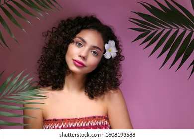 Portrait Of Happy Beautiful Woman With Long Bouncy Curls Hairstyle And Professional Make Up On, Posing Over Isolated Purple Background. Fashion Shot Of Young Gorgeous Female. Close Up, Copy Space.