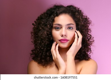 Portrait Of Happy Beautiful Woman With Long Bouncy Curls Hairstyle And Professional Make Up On, Posing Over Grunged Stone Background. Fashion Shot Of Young Gorgeous Female. Close Up, Copy Space.