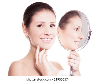portrait of a happy beautiful woman looking into the mirror, isolated against white background