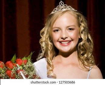 Portrait Of A Happy Beauty Pageant Winner Smiling And Holding Roses