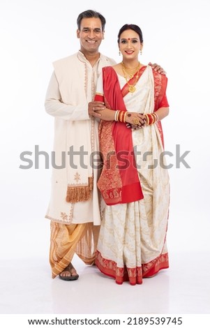 Portrait of happy bengali couple in traditional clothing on occasion of durga puja celebration
