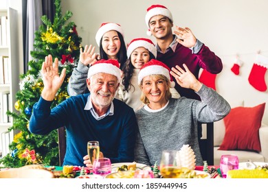 Portrait Of Happy Big Family Celebrating Santa Hats Having Fun And Lunch Together Look At Camera And Say Hi Enjoying Spending Time Together In Christmas Time At Home