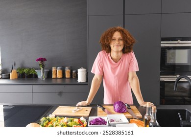 Portrait of happy biracial man with red curly hair preparing meal in modern kitchen, copy space. Food, cooking, healthy lifestyle and domestic life, unaltered. - Powered by Shutterstock