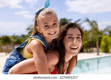 Portrait of happy biracial mother and daughter embracing by the swimming pool. Spending quality time, lifestyle, family, summertime and vacation concept. - Powered by Shutterstock