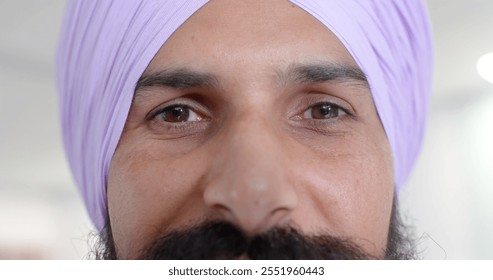 Portrait of happy biracial sikh male doctor in turban looking at camera at hospital, in slow motion. Hospital, medicine and healthcare. - Powered by Shutterstock