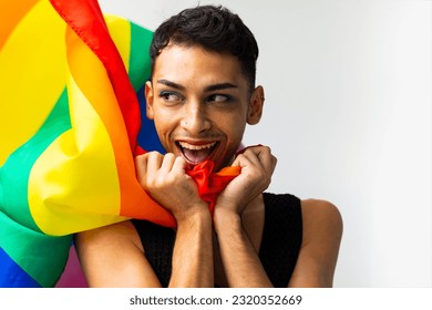 Portrait of happy biracial transgender man holding rainbow flag on white background, copy space. Gender, lgbtq, pride and lifestyle, unaltered. - Powered by Shutterstock