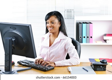 Portrait Of Happy Black Business Woman At Desk Typing On Computer