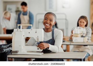 Portrait Of Happy Black Fashion Designer Working On Clothes In A Workshop. Diverse Group Of Students Doing An Internship At A Clothing Factory, Learning About The Industry And How To Sew On Machine