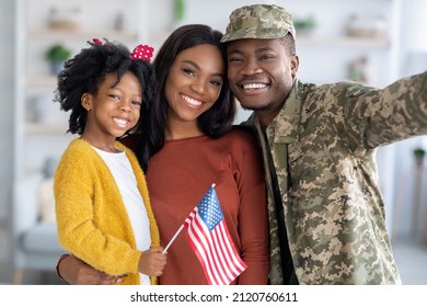 Portrait Of Happy Black Military Man Taking Selfie With Wife And Little Daughter At Home, Happy Family Celebrating Reunion And Smiling At Camera, Cute Girl Holding American Flag, Closeup