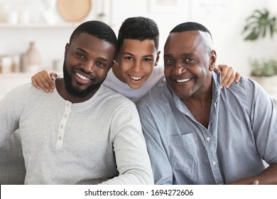 Portrait Of Happy Black Son, Father And Grandfather Posing For Family Picture Together, Sitting On Couch At Home And Looking At Camera, Closeup