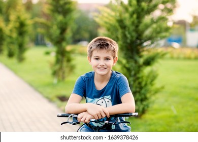 Portrait Of A Happy Boy Of 8-9 Years On A Bicycle In The Summer