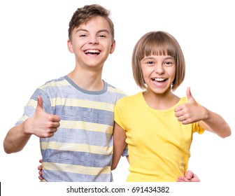 Portrait Of Happy Boy And Girl Showing Thumbs Up Gesture. Cute Brother And Sister Isolated On White Background. Funny Couple Children Laughing With A Perfect Smile. 