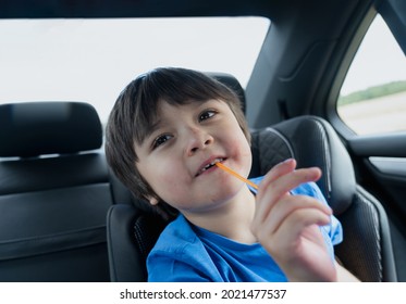 Portrait Happy Boy  With Messy Face Of Strawberry Bitting Plastic Straw, Child Siting In Safety Car Seat Looking Up With Smiling Face, Cute Mixed Race Kid With Funny Face.