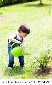Portrait of Happy Boy Watering Plants Outdoors